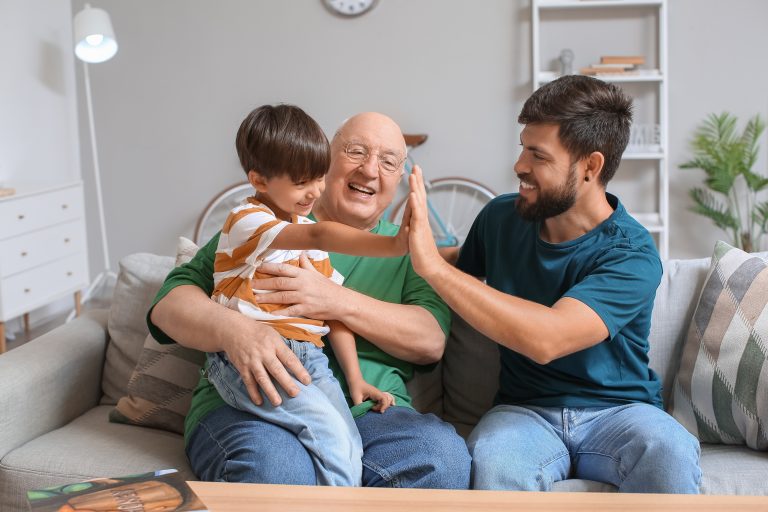 Happy man, his little son and father at home